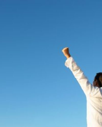 Person holding hands over head in winning 'yes' posture