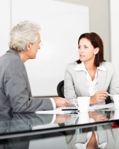 Man and woman sitting at desk talking